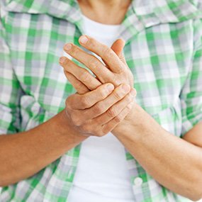 Symptoms of Arthritis, man clenching knuckles